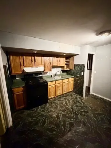 a kitchen with stainless steel appliances granite countertop a stove a sink and a refrigerator