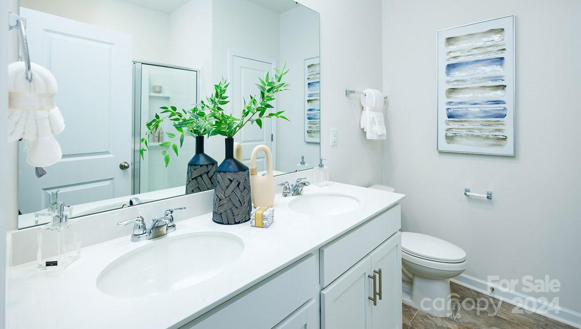 186 Wheatfield Road Fletcher, NC 28732 - Photo 16 of 25 a bathroom with a granite countertop sink a toilet and a mirror