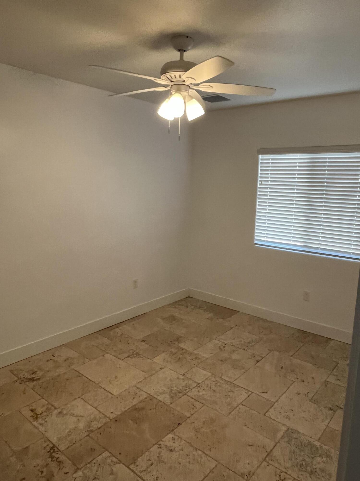 639 Cabrera Street Key Largo, FL 33037 - Photo 20 of 24 an empty room with a chandelier fan and windows