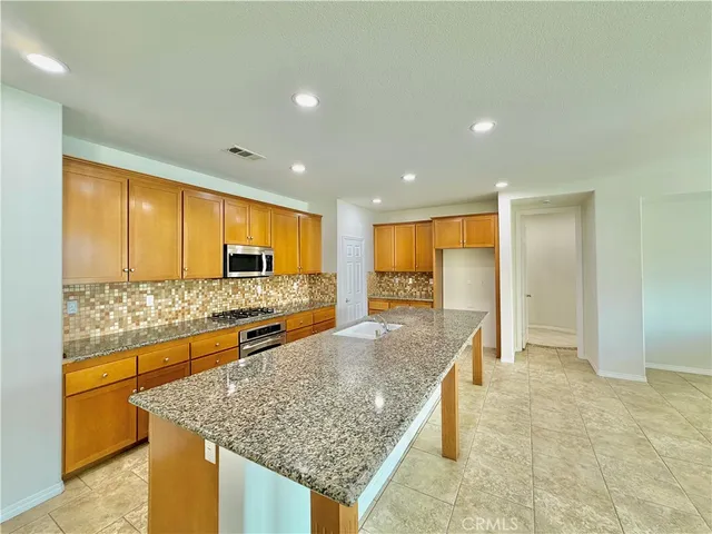 a large kitchen with kitchen island a sink and a large window