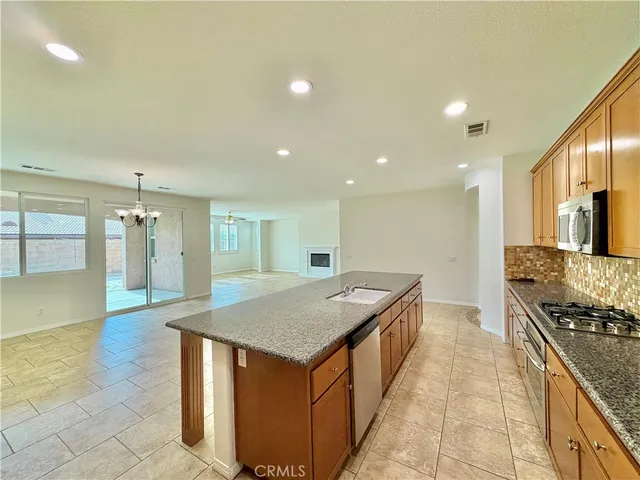 a kitchen with stainless steel appliances granite countertop a sink and a refrigerator