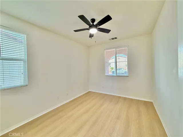 an empty room with window and ceiling fan