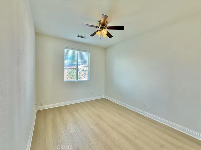 an empty room with windows and fan