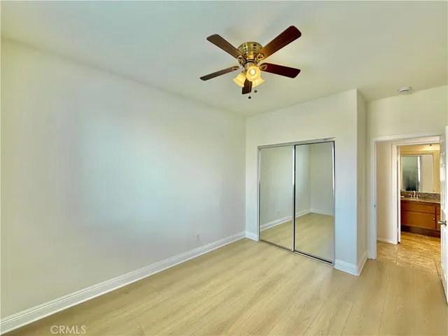 an empty room with closet and fan