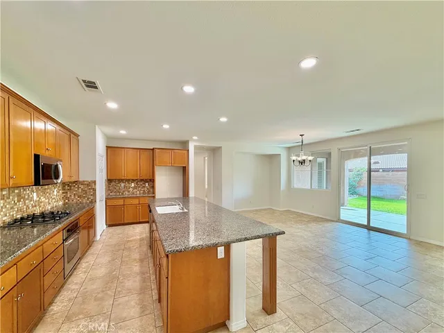 a large kitchen with kitchen island granite countertop a large counter top and sink