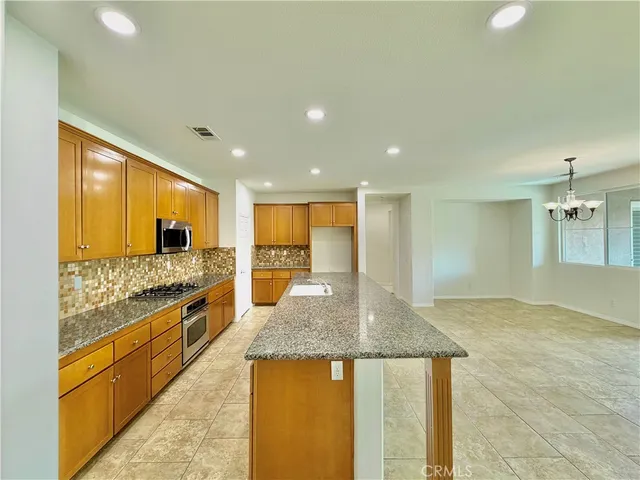 a large kitchen with kitchen island a sink stainless steel appliances and a counter top space