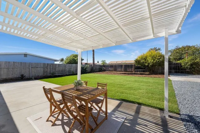 a view of a patio with table and chairs with wooden fence