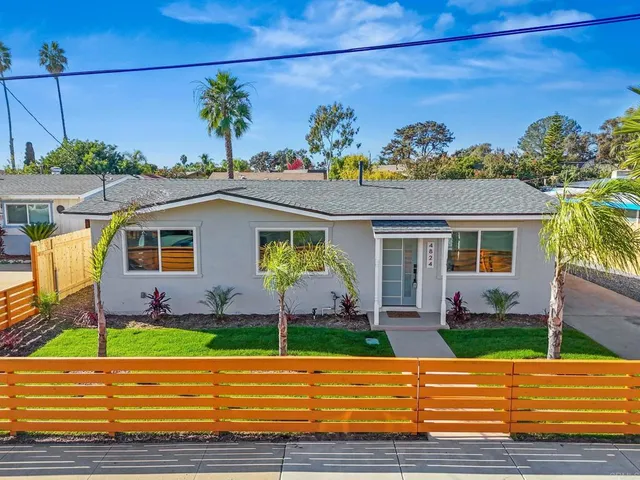a view of a house with a small yard and potted plants