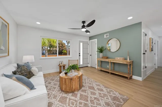 a living room with furniture a window and a potted plant