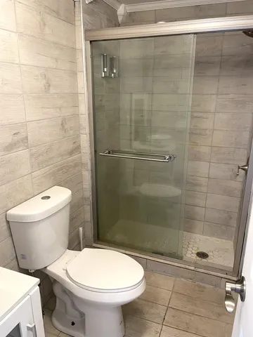 a bathroom with a toilet and a shower
