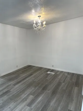 a view of a room with wooden floor and chandelier