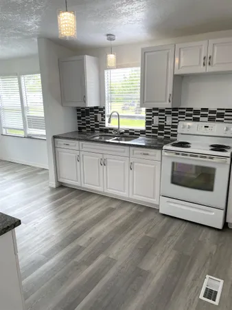 a kitchen with stainless steel appliances granite countertop a stove a sink and a microwave