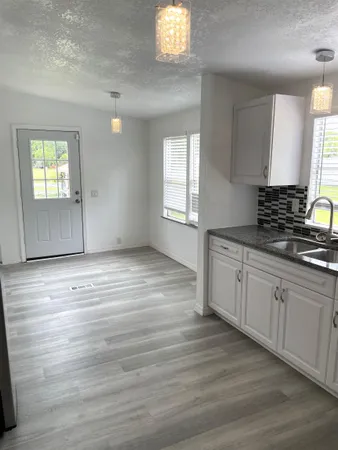 a view of a kitchen with wooden floor and a window