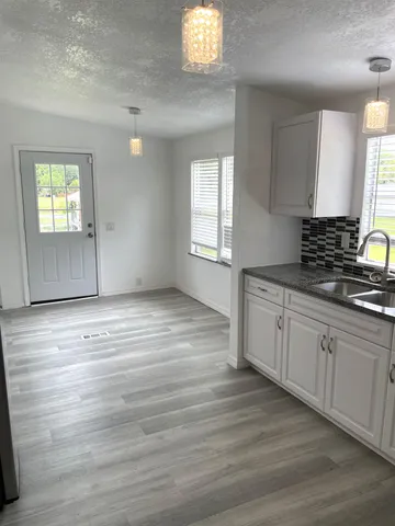 a view of a kitchen with wooden floor and a window