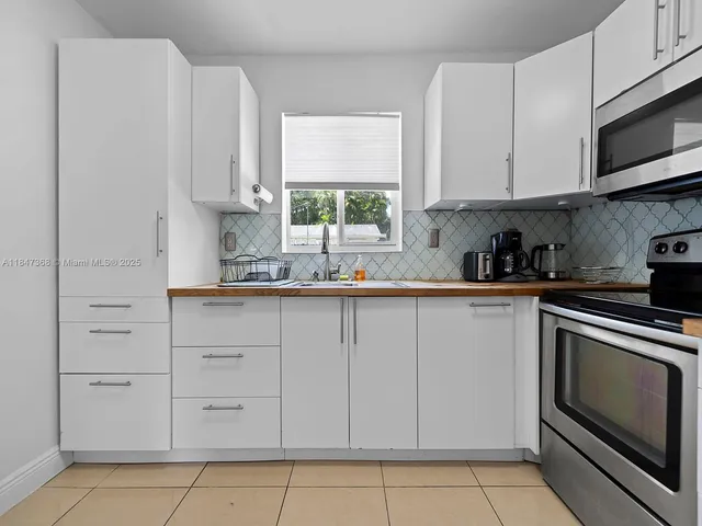 a kitchen with white cabinets stainless steel appliances and sink