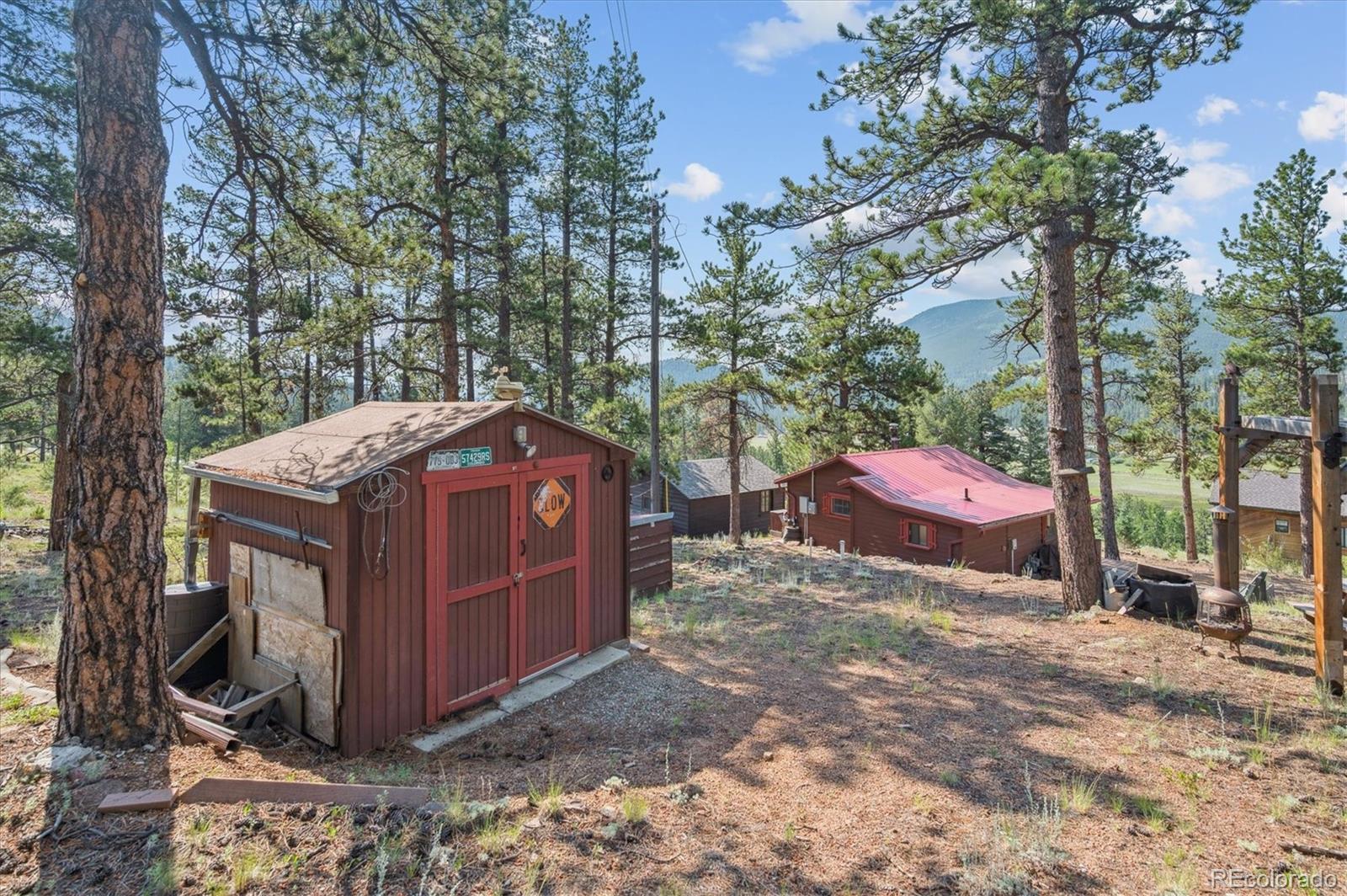 990 Rd P69 Bailey, CO 80421 - Photo 17 of 17 a view of a wooden house with a yard
