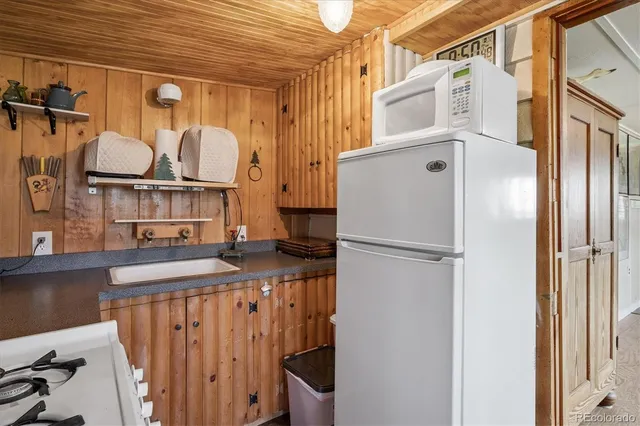 a kitchen with a sink a stove and a wooden cabinets
