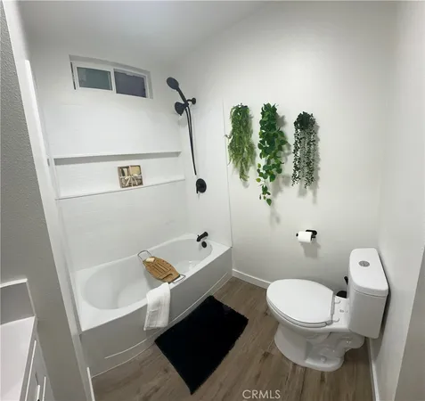 a white toilet sitting next to a bathroom sink and tub