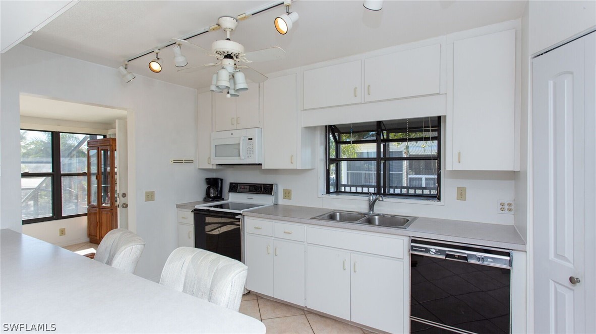 360 Bayland Road Fort Myers Beach, FL 33931 - Photo 11 of 35 a kitchen with a sink stove and cabinets