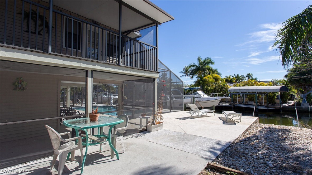 360 Bayland Road Fort Myers Beach, FL 33931 - Photo 24 of 35 a view of a patio with a table and chairs under an umbrella