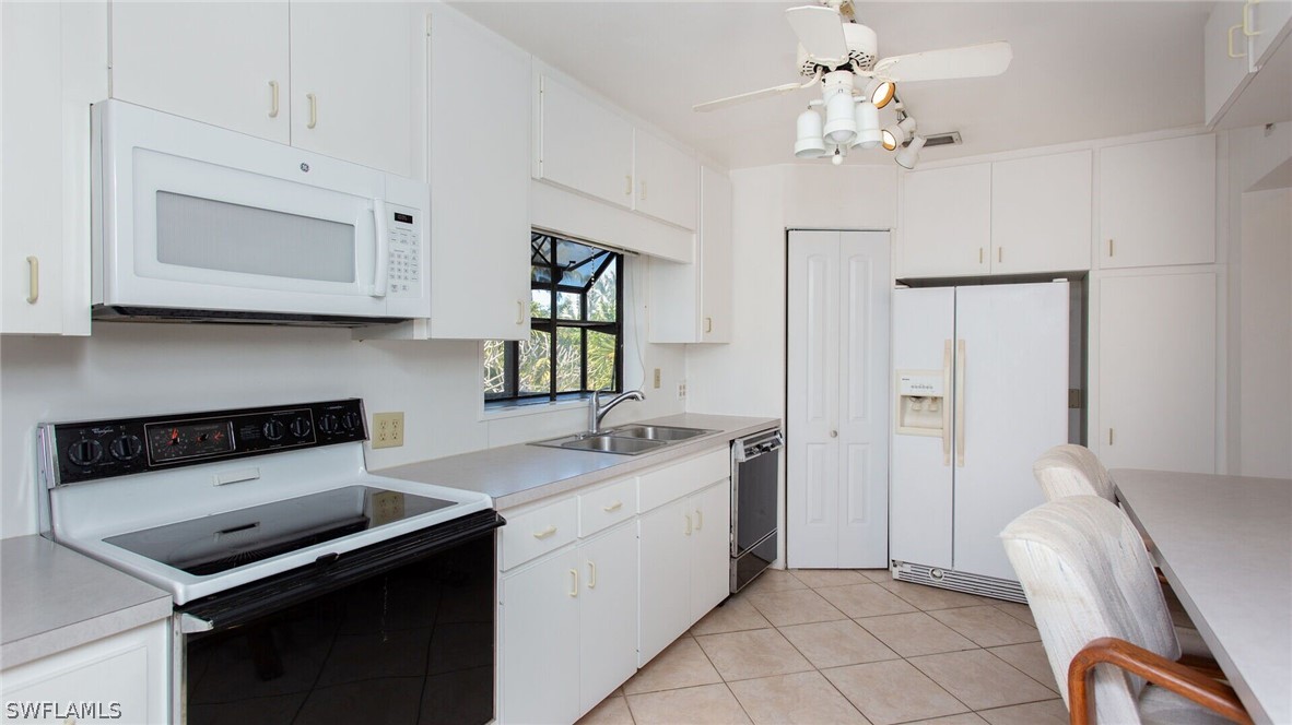 360 Bayland Road Fort Myers Beach, FL 33931 - Photo 9 of 35 a kitchen that has a sink and a stove in it
