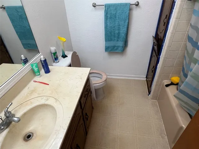a en suite bathroom with a granite countertop sink and a mirror