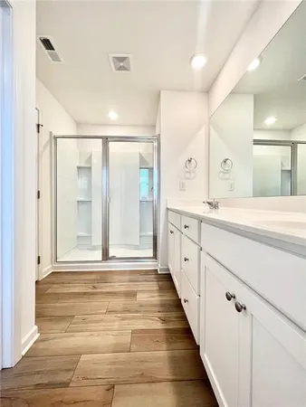 a spacious bathroom with a shower sink and mirror