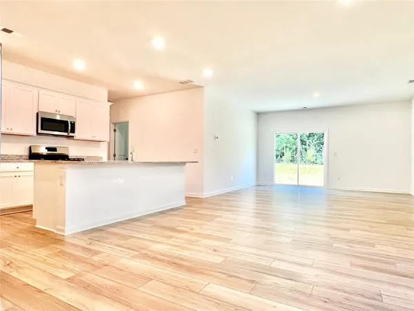 a view of a kitchen with wooden floor and a sink