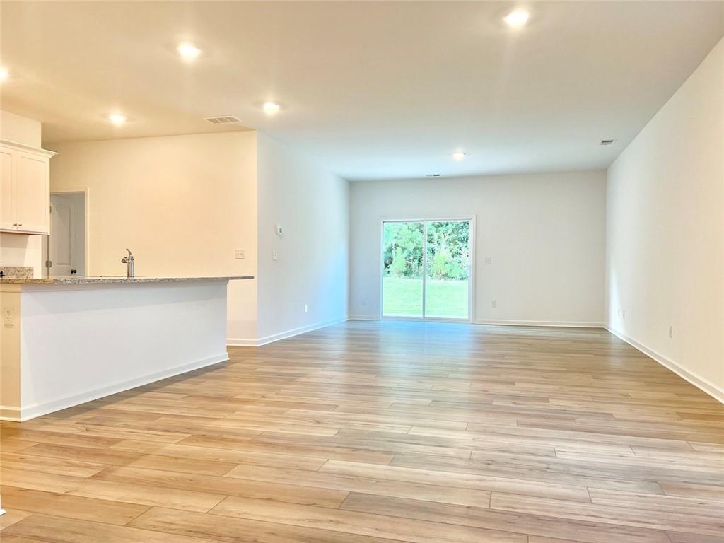 1529 Hay Patch Lane Loganville, GA 30052 - Photo 4 of 24 an empty room with wooden floor and windows
