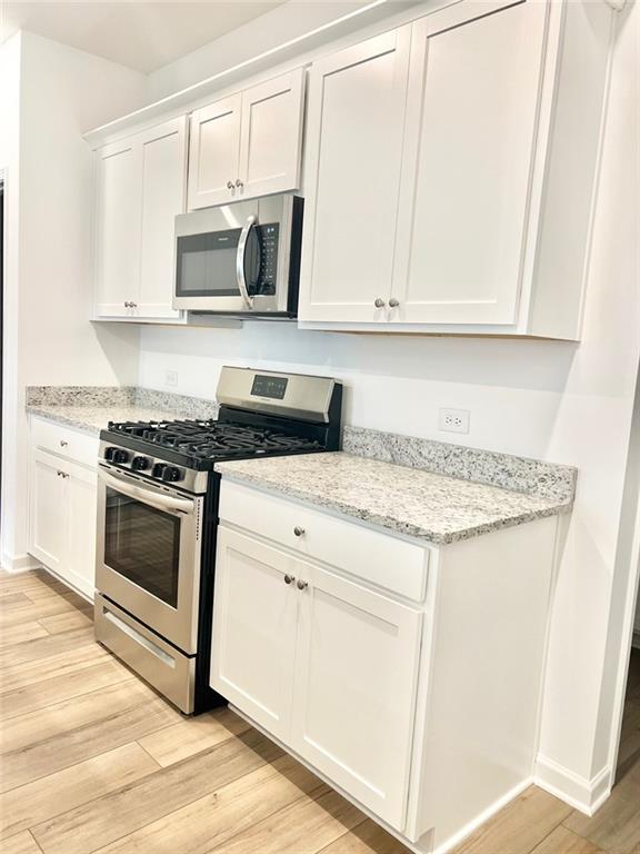 1529 Hay Patch Lane Loganville, GA 30052 - Photo 6 of 24 a kitchen with granite countertop white cabinets and stainless steel appliances