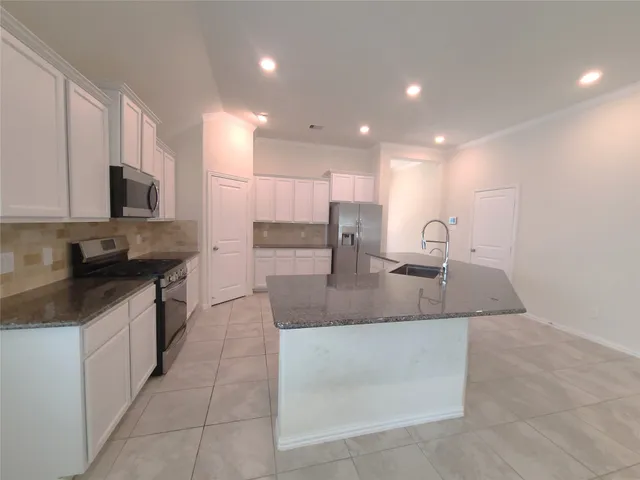 a large kitchen with a large counter top a sink a stove a microwave and island