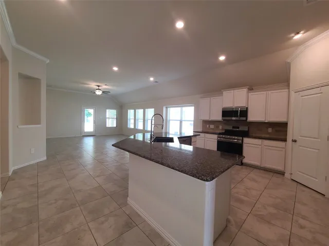 a kitchen with stainless steel appliances granite countertop a sink and stove