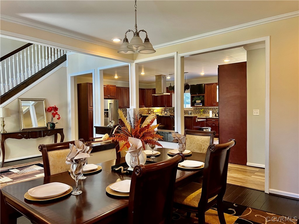 16714 Harrowgate Road Colonial Heights, VA 23834 - Photo 10 of 39 a dining room with furniture a chandelier and wooden floor