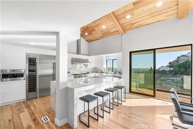 a kitchen with stainless steel appliances kitchen island granite countertop a refrigerator a stove top oven and white cabinets