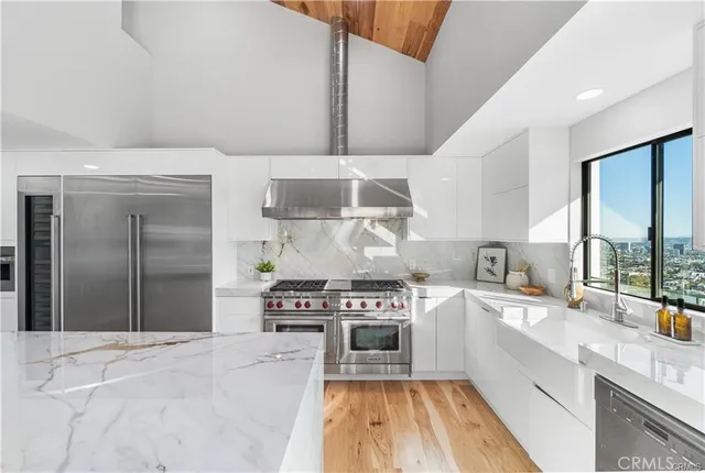a kitchen with stainless steel appliances a stove a sink and a refrigerator