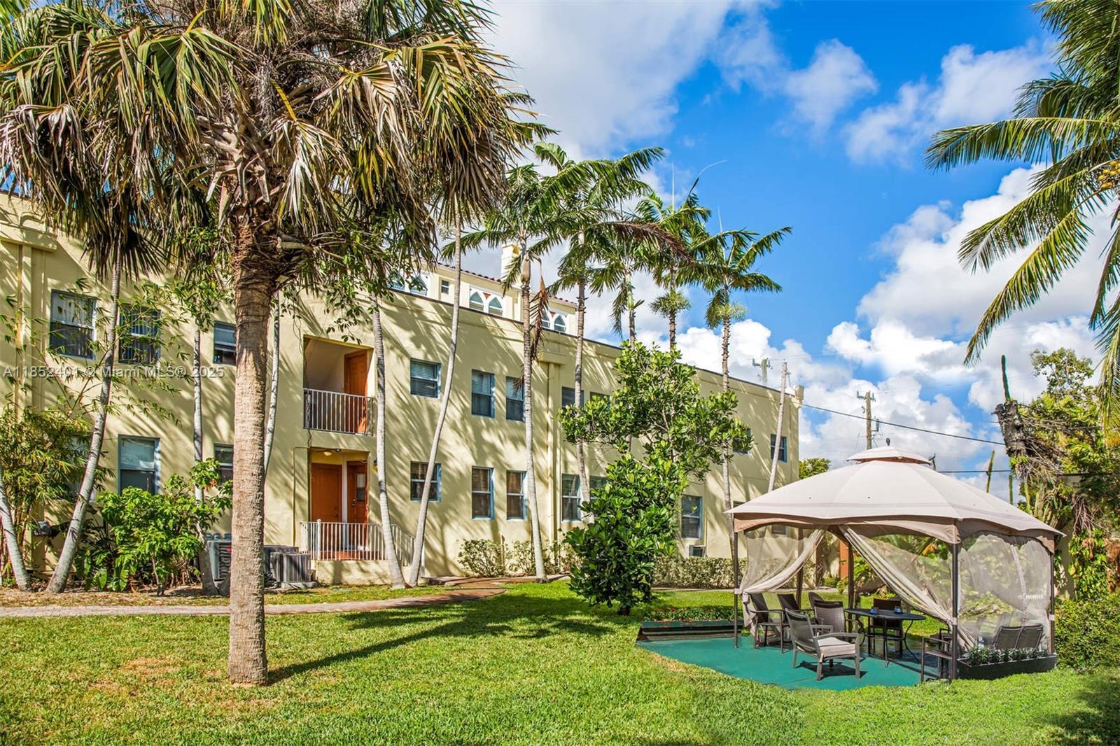 421 Grand Concourse, Unit 6 Miami Shores, FL 33138 - Photo 7 of 8 a view of a white house with a yard table and chairs