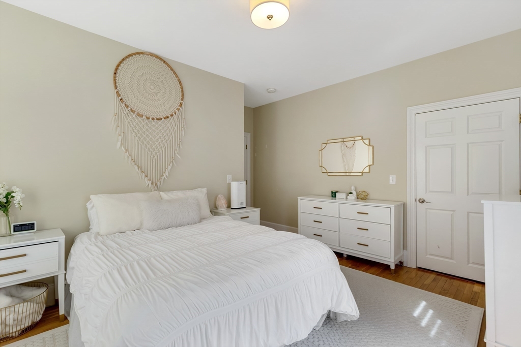 34 Warren Street, Unit 3 Stoneham, MA 02180 - Photo 15 of 34 a bedroom with a bed and a chandelier