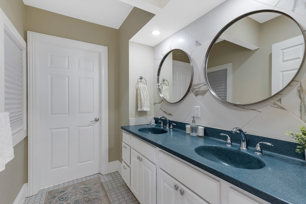 34 Warren Street, Unit 3 Stoneham, MA 02180 - Photo 18 of 34 a bathroom with a granite countertop double vanity sinks and a mirror