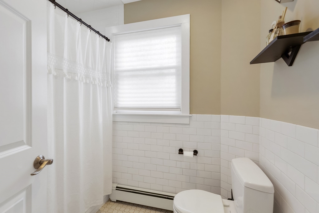 34 Warren Street, Unit 3 Stoneham, MA 02180 - Photo 19 of 34 a bathroom with a shower curtain