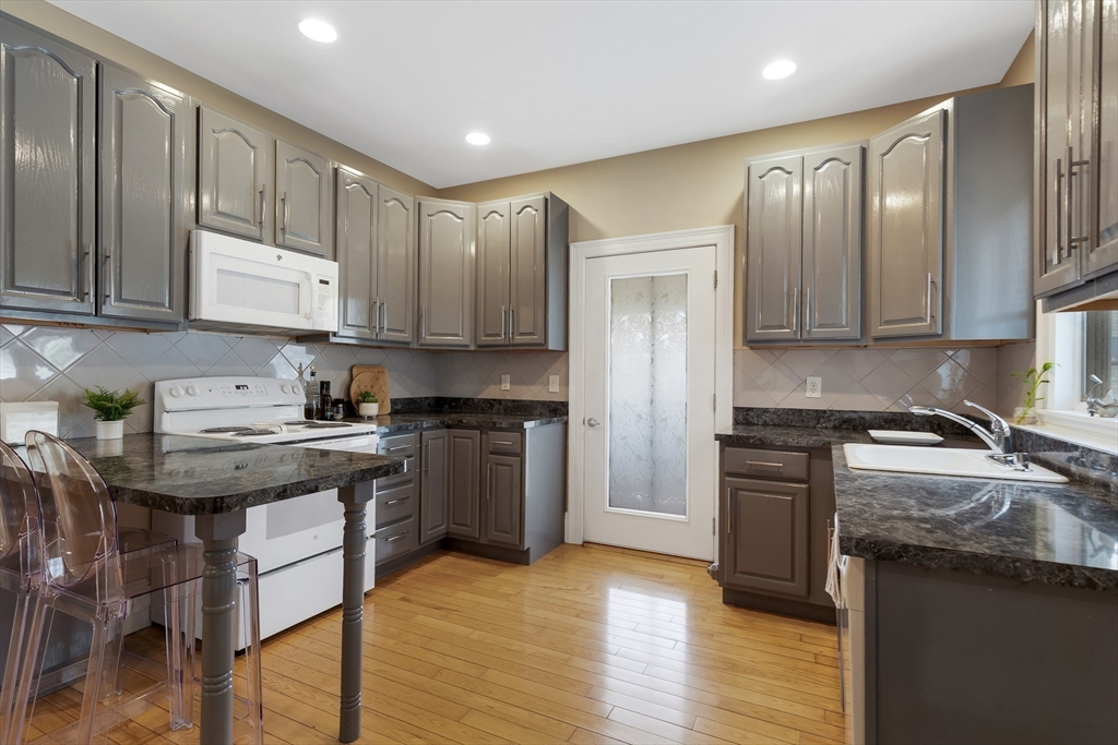 34 Warren Street, Unit 3 Stoneham, MA 02180 - Photo 5 of 34 a kitchen with a stove a sink and a refrigerator