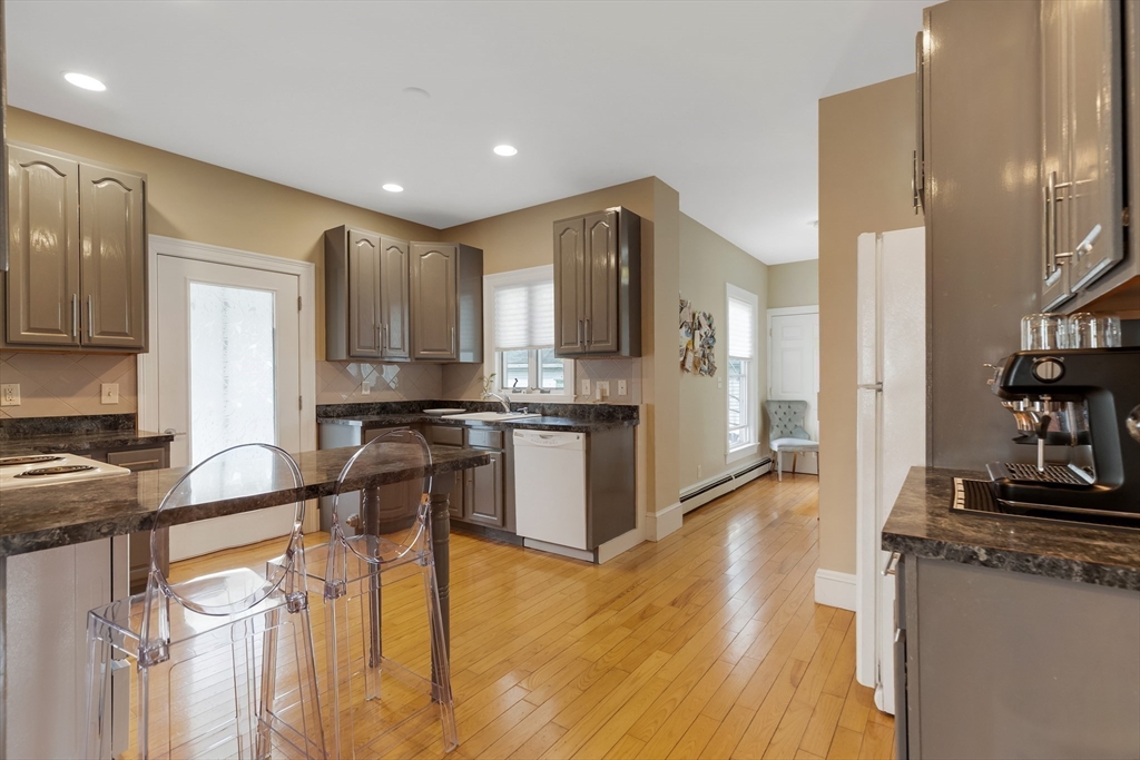 34 Warren Street, Unit 3 Stoneham, MA 02180 - Photo 7 of 34 a kitchen with stainless steel appliances granite countertop a refrigerator and a stove top oven