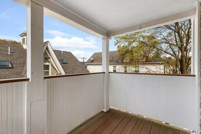 a view of a balcony with wooden floor and fence