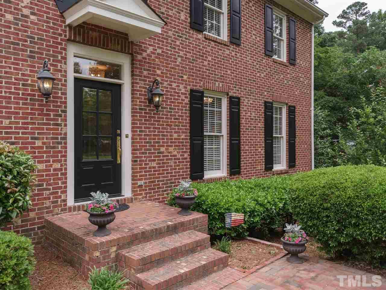 7405 Glendower Road Raleigh, NC 27613 - Photo 2 of 25 a view of a brick house with a yard and plants
