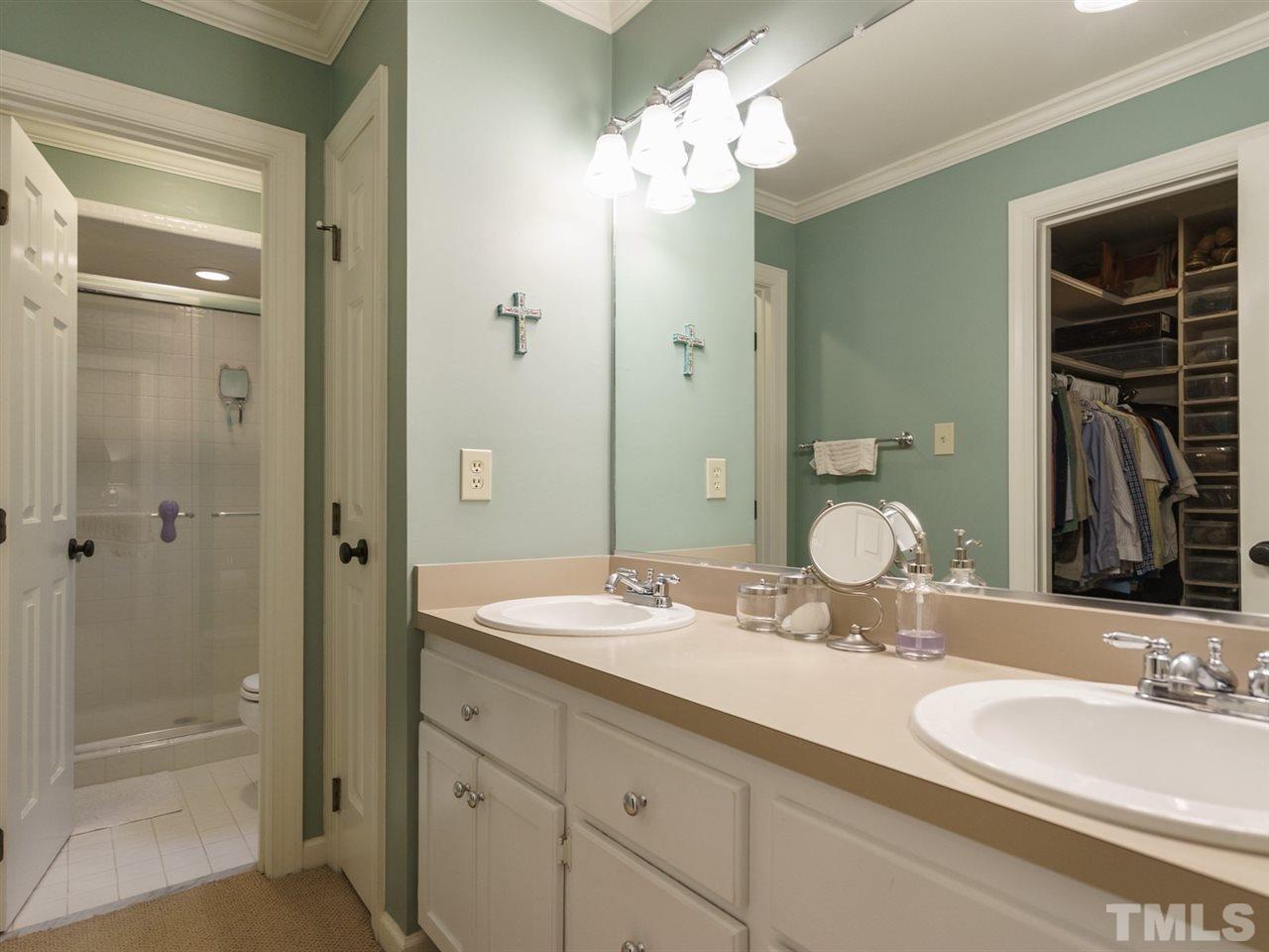 7405 Glendower Road Raleigh, NC 27613 - Photo 15 of 25 a bathroom with a granite countertop double vanity sinks a vanity a mirror and shower