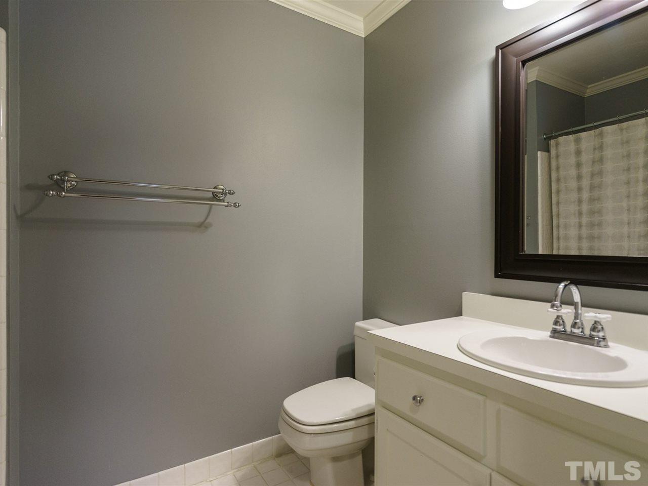 7405 Glendower Road Raleigh, NC 27613 - Photo 17 of 25 a bathroom with a toilet sink and mirror
