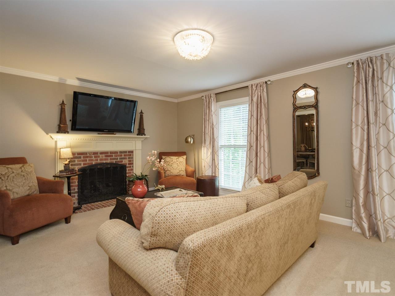 7405 Glendower Road Raleigh, NC 27613 - Photo 5 of 25 a living room with furniture a fireplace and a flat screen tv