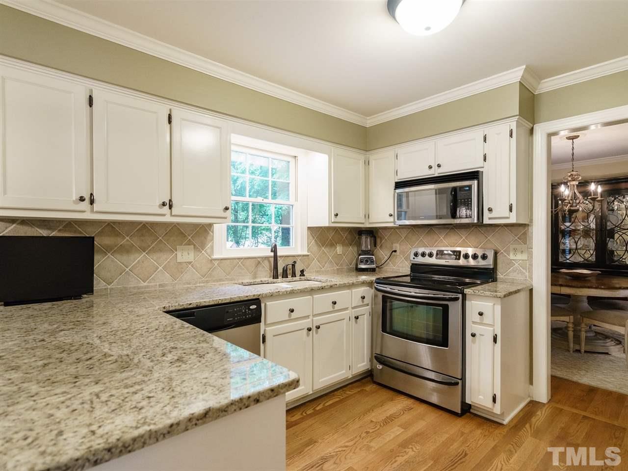 7405 Glendower Road Raleigh, NC 27613 - Photo 8 of 25 a kitchen with stainless steel appliances granite countertop a stove a sink and a microwave