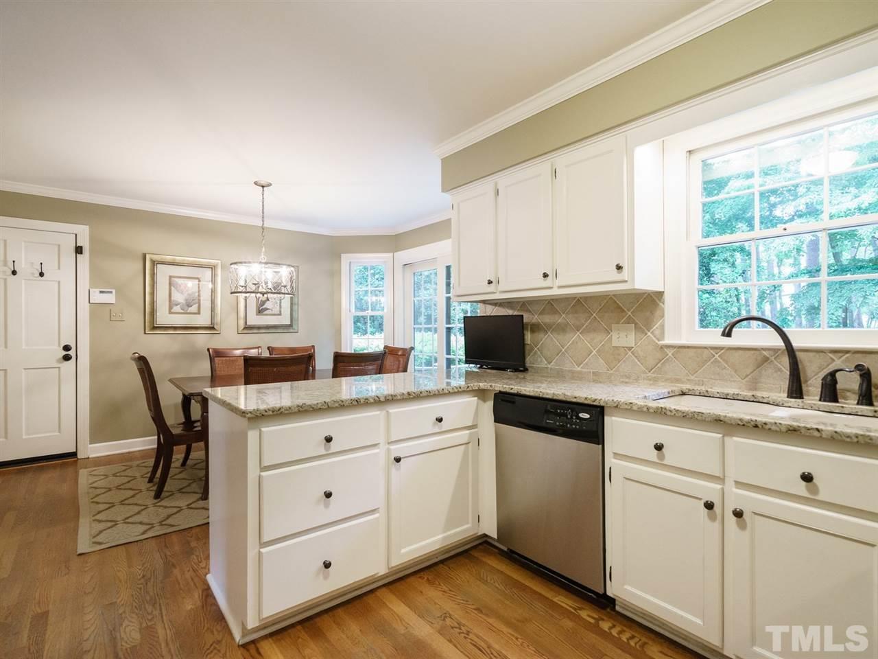7405 Glendower Road Raleigh, NC 27613 - Photo 10 of 25 a kitchen with granite countertop white cabinets and white appliances