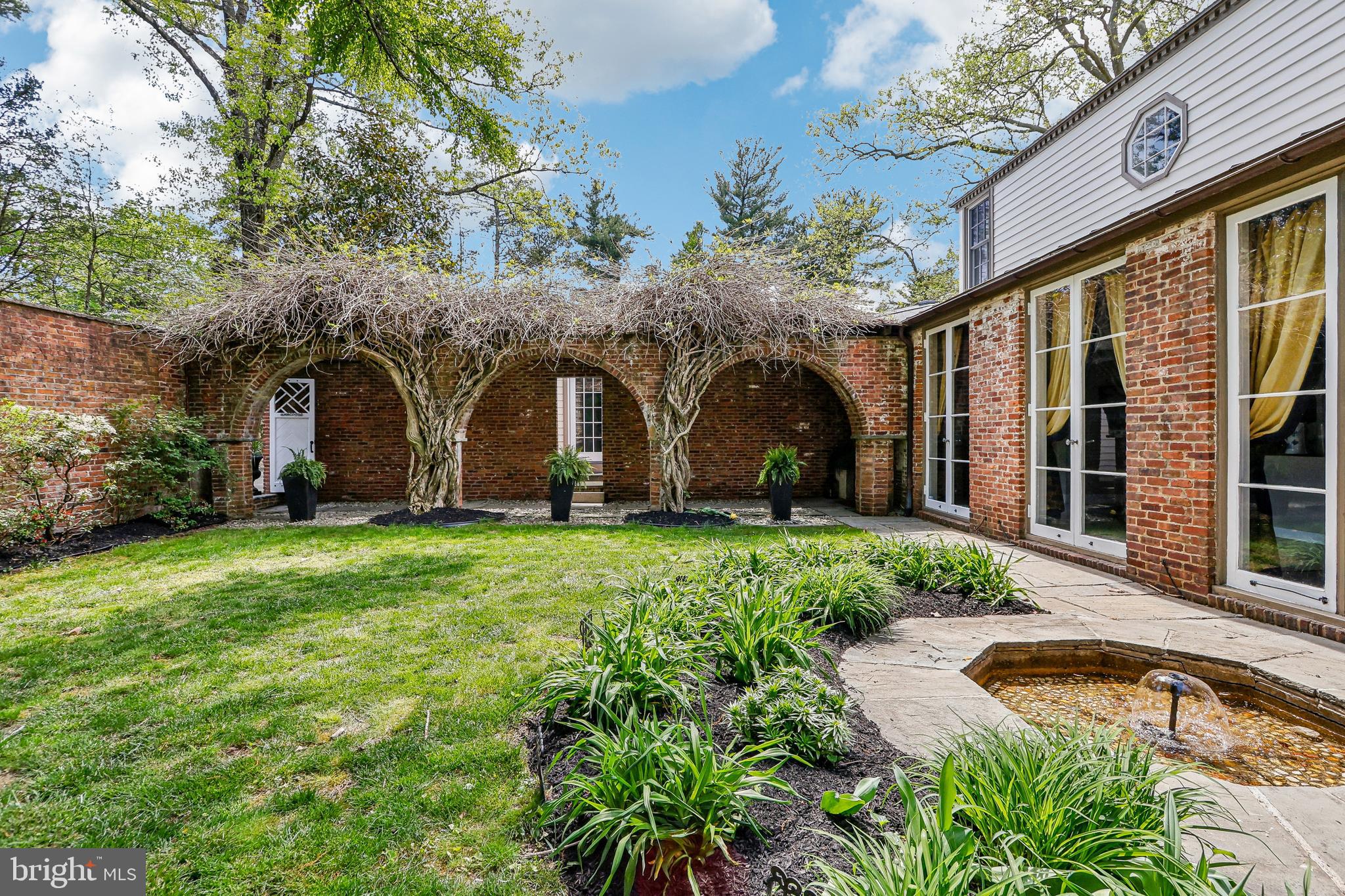 a view of a house with brick walls and a yard with potted plants