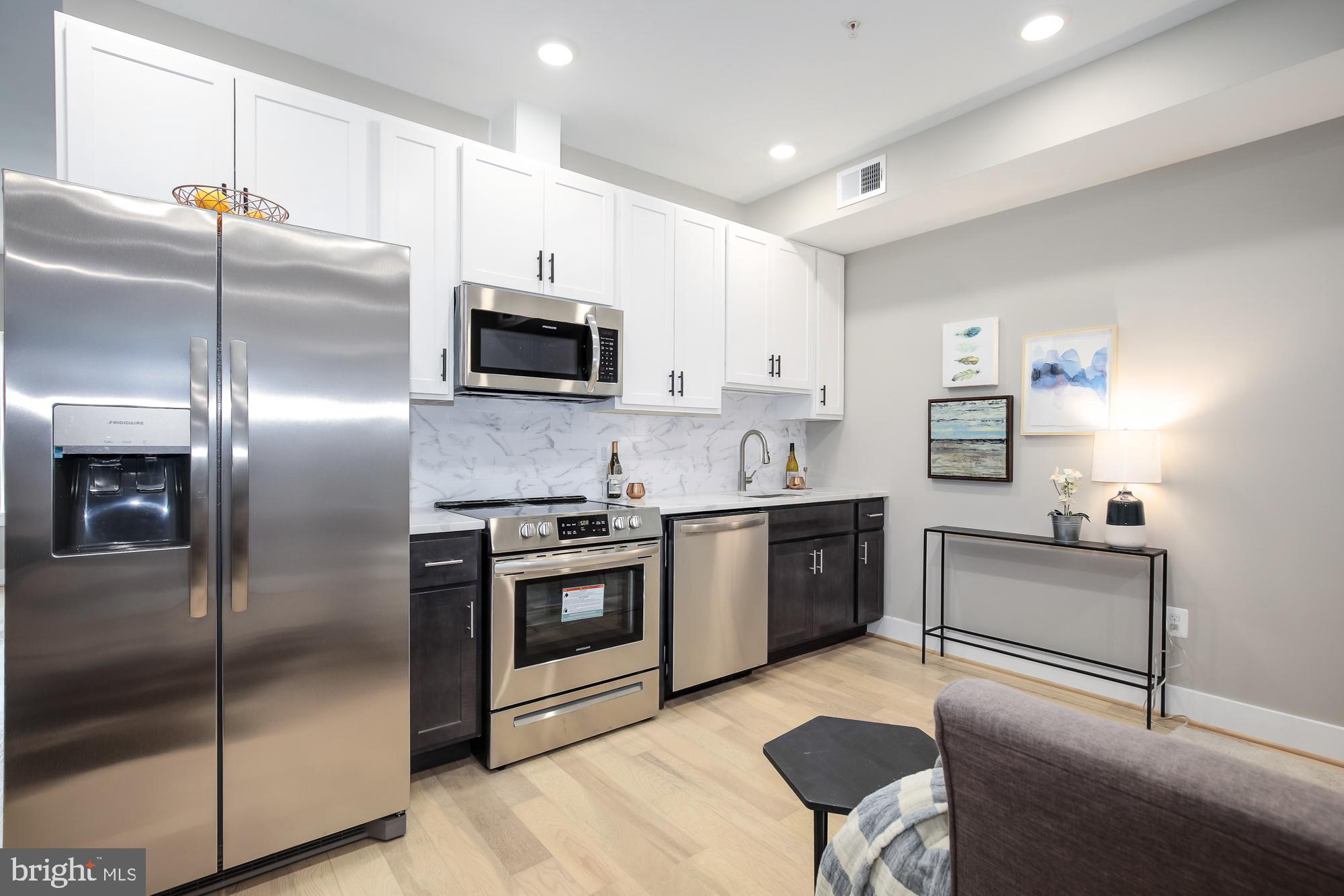 505 Kennedy Street Northwest, Unit 2 Washington, DC 20011 - Photo 3 of 15 a kitchen with stainless steel appliances granite countertop a refrigerator a stove a sink and a microwave